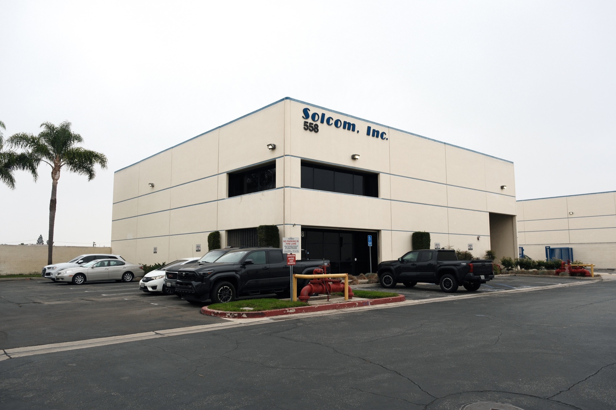 558 Amapola Ave corner elevation with Solcom Inc. signage and reserved parking
