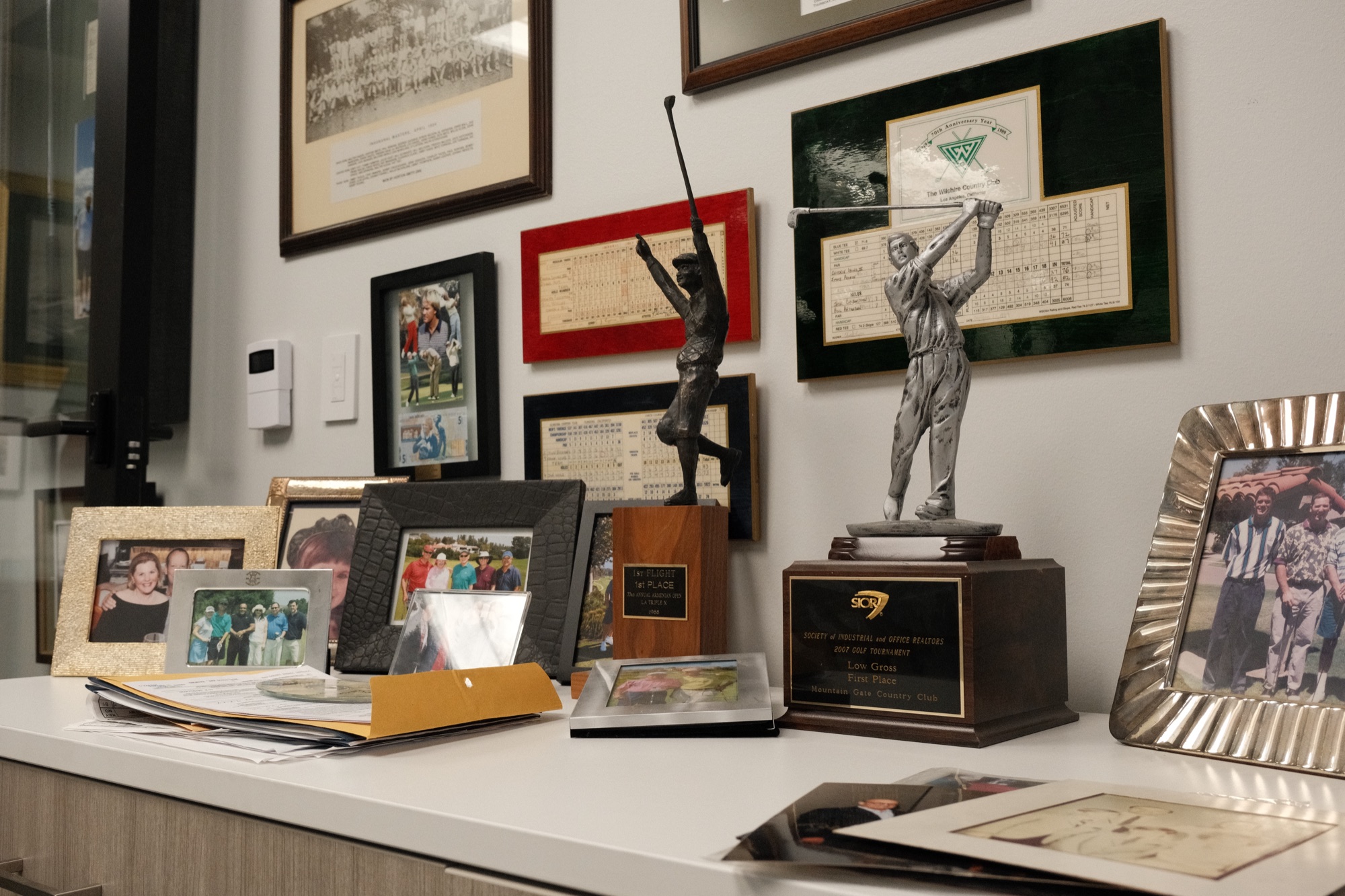 Desk of SIOR and golf tournament awards spanning decades of the firm's history