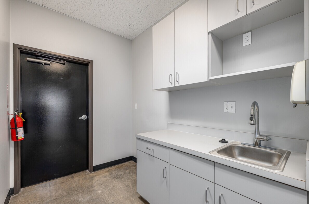 Office kitchenette with upper cabinets and stainless sink