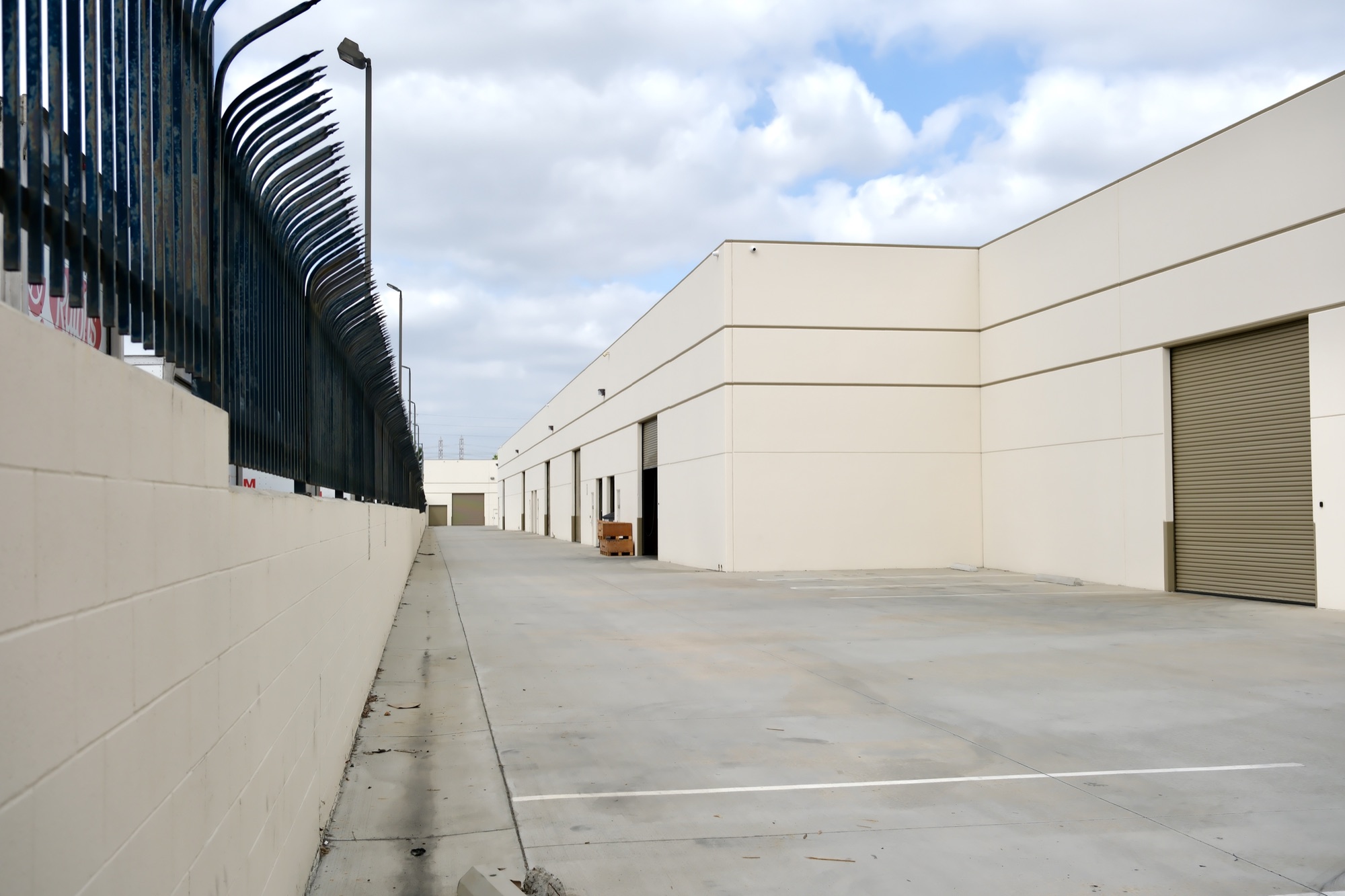 Service alley between buildings along the Garfield Avenue corridor with fenced loading areas
