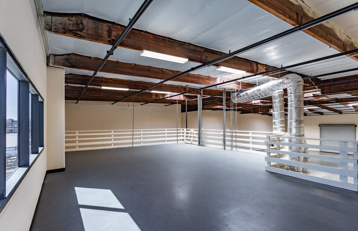 Open mezzanine level with perimeter railing and exposed ductwork