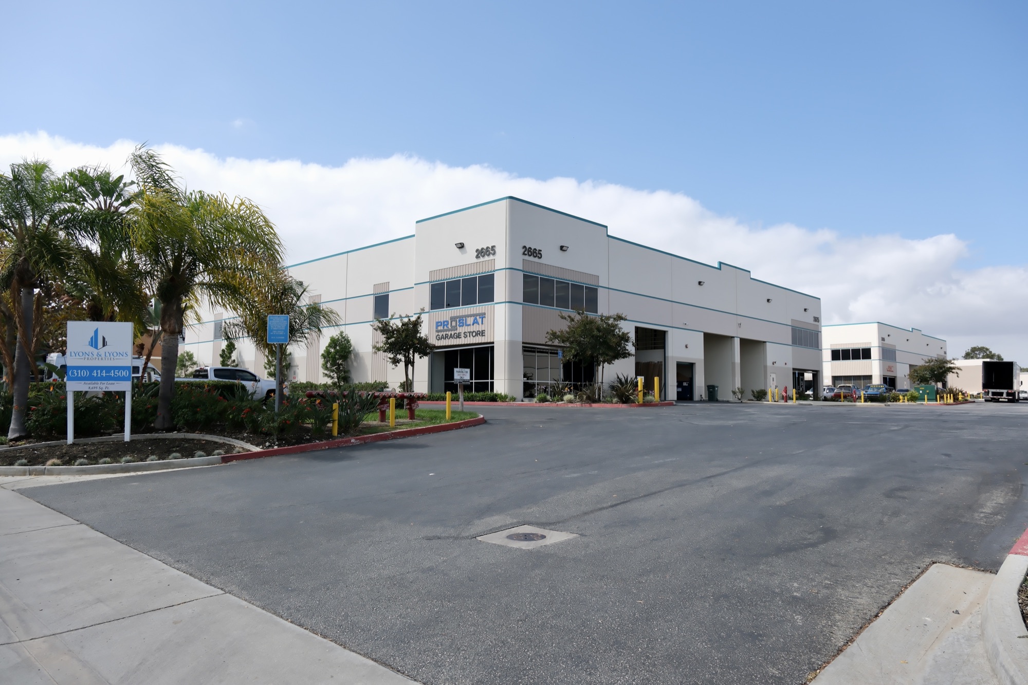 2665 Temple Ave with Proslat Garage Store signage and a Lyons & O’Brien R.E. leasing sign