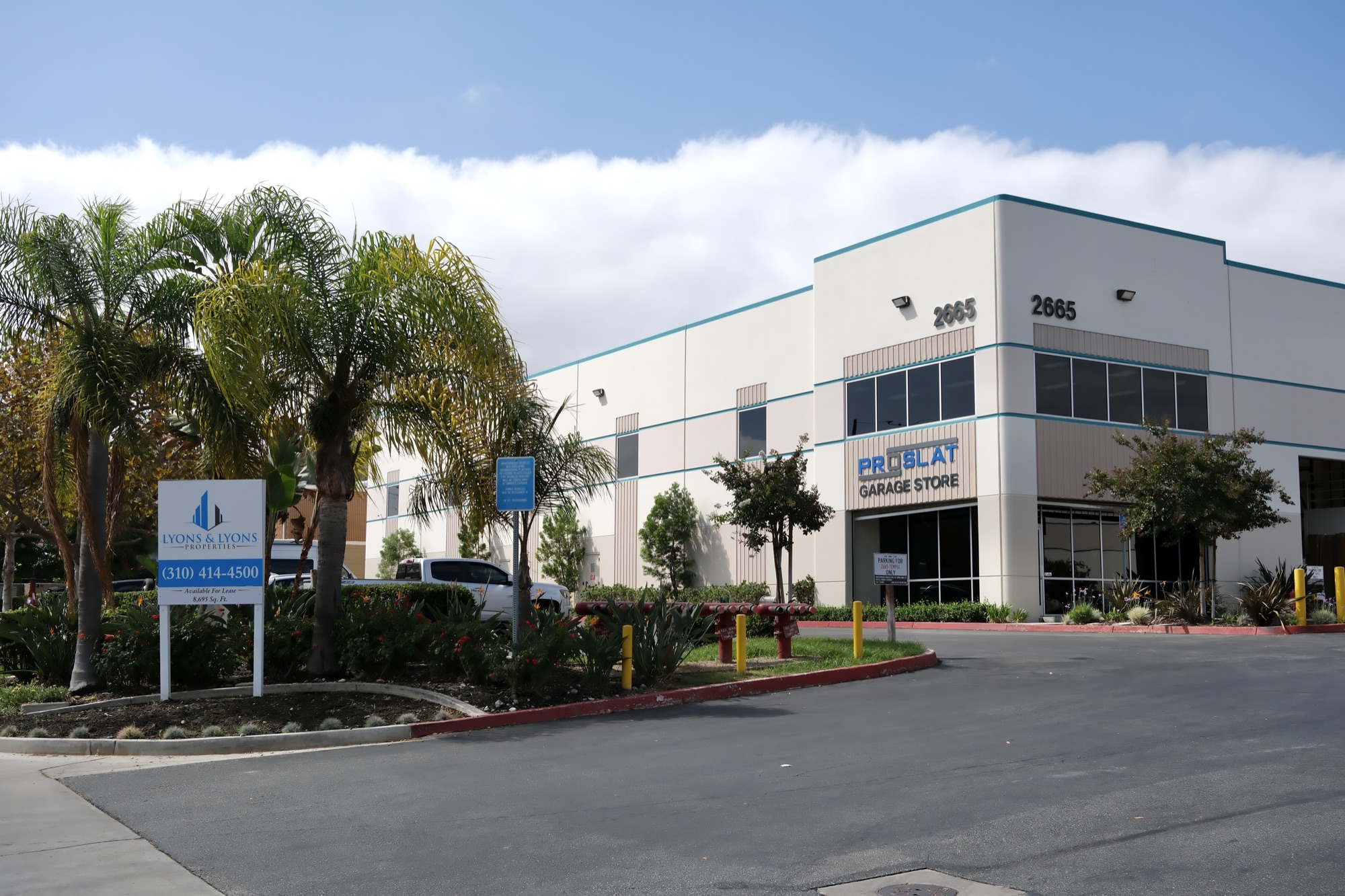 2665 Temple Ave with Proslat Garage Store signage and a Lyons & O’Brien R.E. leasing sign