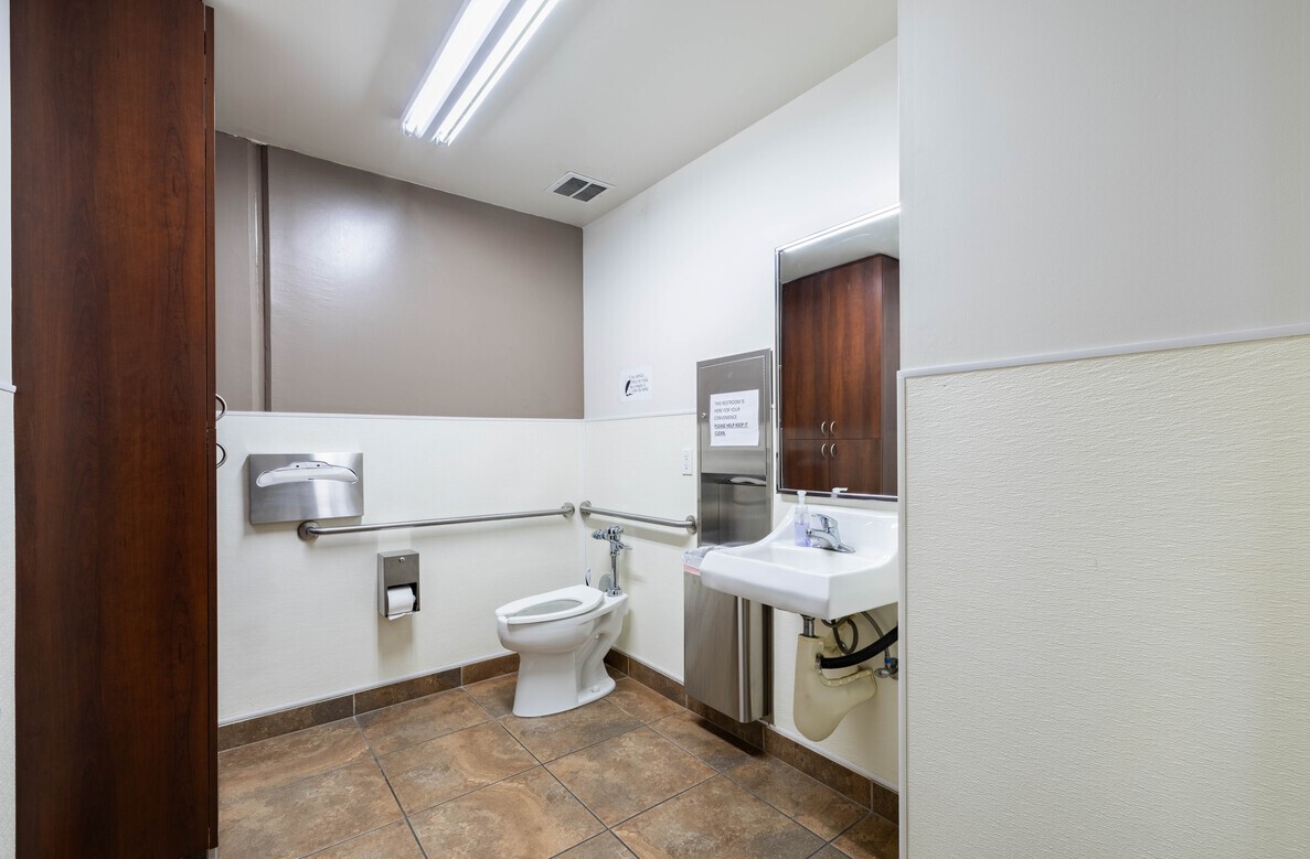 Accessible restroom with tile flooring and stainless fixtures