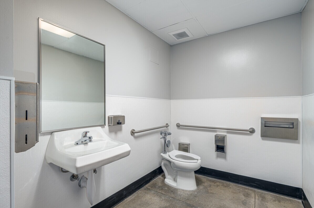 Accessible restroom with grab bars and stainless fixtures