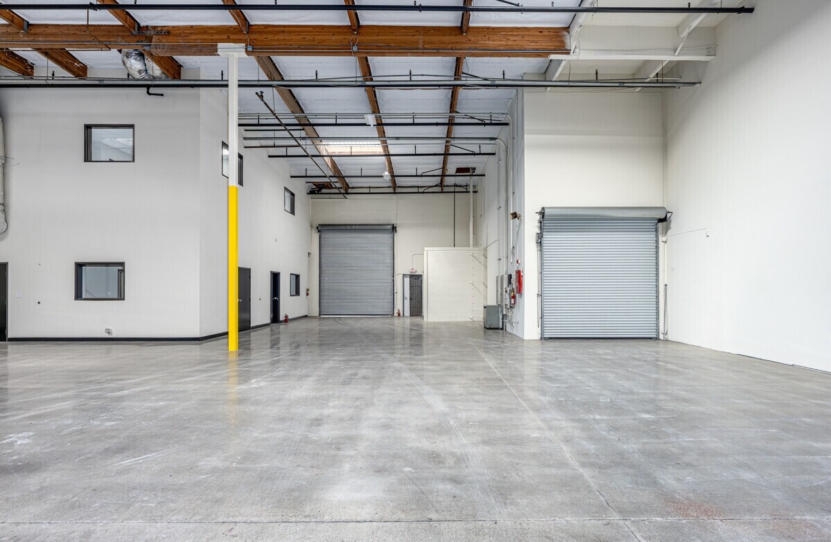 Vacant warehouse interior at 7729 Somerset Blvd with two grade-level roll-up doors