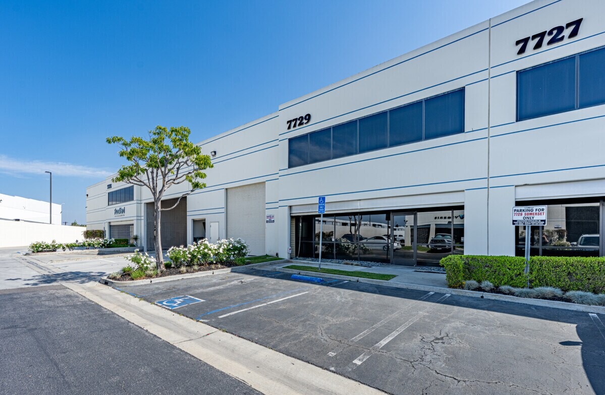 7729 Somerset Blvd building elevation with glazed office entry, grade-level door and landscaping