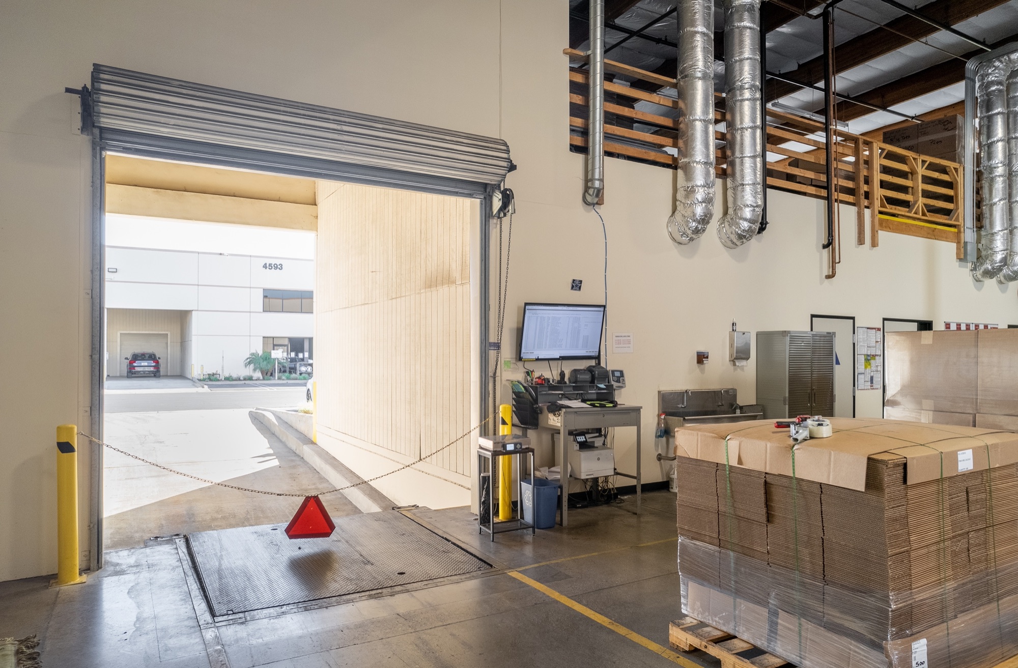 Interior dock-high loading door with leveler